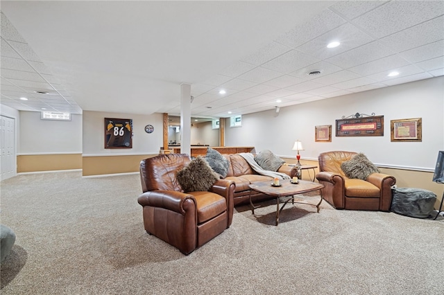 living room featuring carpet and a paneled ceiling