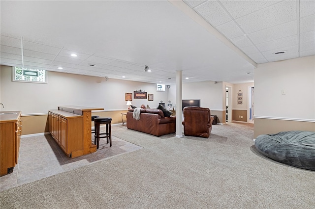 carpeted living room with a paneled ceiling