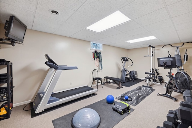 workout area featuring carpet flooring and a paneled ceiling