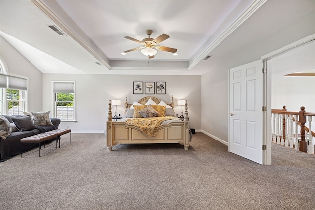 carpeted bedroom with ceiling fan, a raised ceiling, and ornamental molding