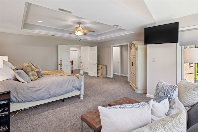 bedroom featuring a tray ceiling, carpet, and ceiling fan