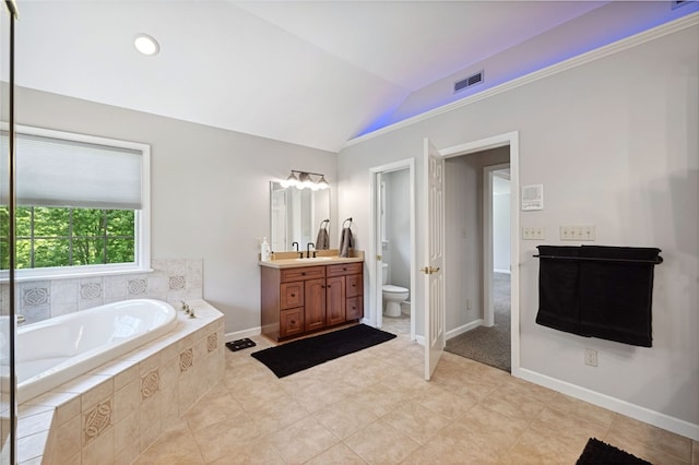 bathroom featuring toilet, tile flooring, tiled bath, vanity, and lofted ceiling