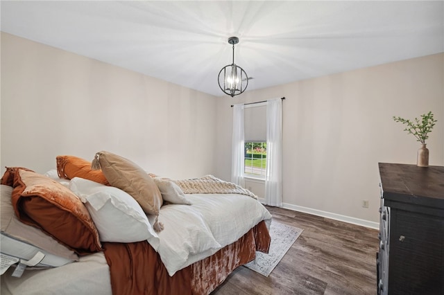 bedroom with a chandelier and dark wood-type flooring