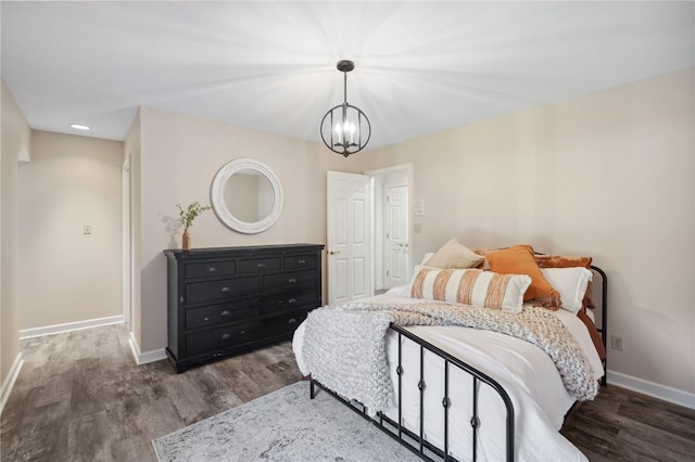 bedroom with a notable chandelier and dark hardwood / wood-style flooring