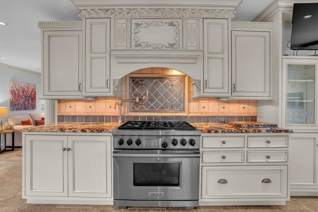 kitchen with designer range, tasteful backsplash, crown molding, dark stone countertops, and light tile floors