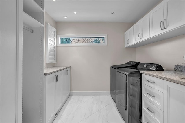 clothes washing area with washer and clothes dryer, cabinets, and light tile floors