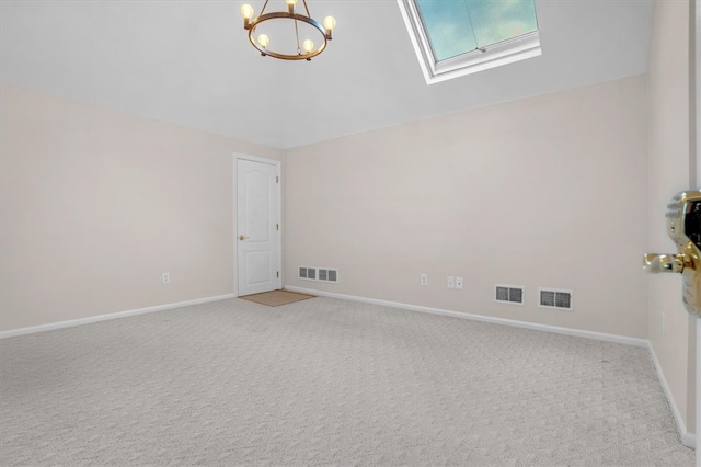 carpeted empty room with an inviting chandelier and a skylight