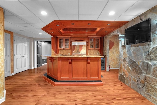 kitchen featuring light stone counters, light hardwood / wood-style floors, and a paneled ceiling