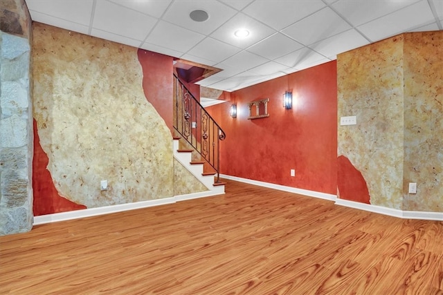 basement with hardwood / wood-style flooring and a paneled ceiling