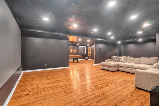 living room with light hardwood / wood-style floors and a drop ceiling