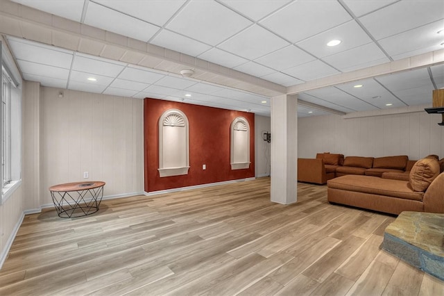 living room featuring light wood-type flooring and a drop ceiling