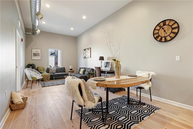 dining area featuring a high ceiling and light wood-type flooring