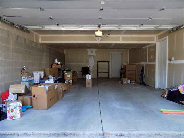 garage featuring concrete block wall and a garage door opener