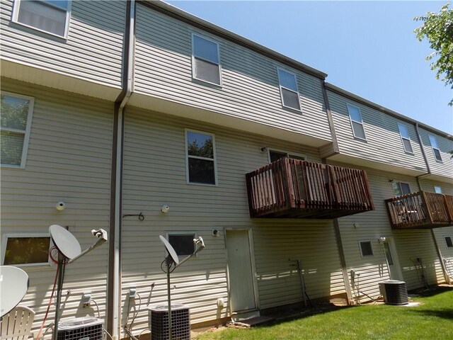 back of house with central AC, a balcony, and a yard