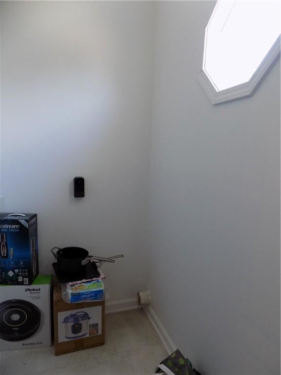 laundry area featuring light tile patterned flooring and baseboards