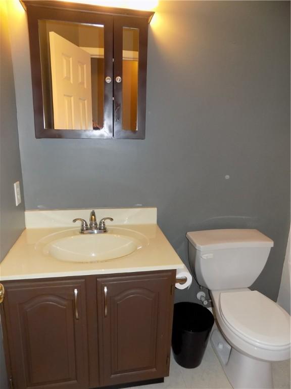 bathroom with tile patterned flooring, vanity, and toilet