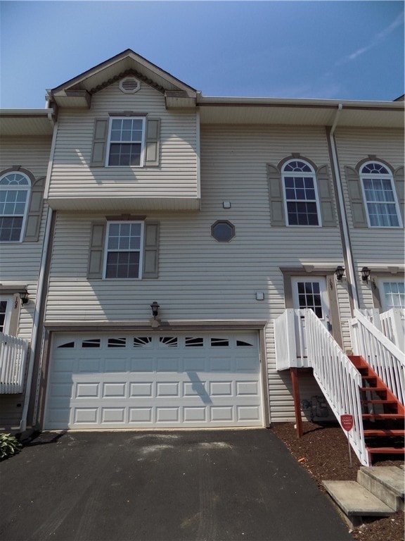 multi unit property featuring aphalt driveway and an attached garage