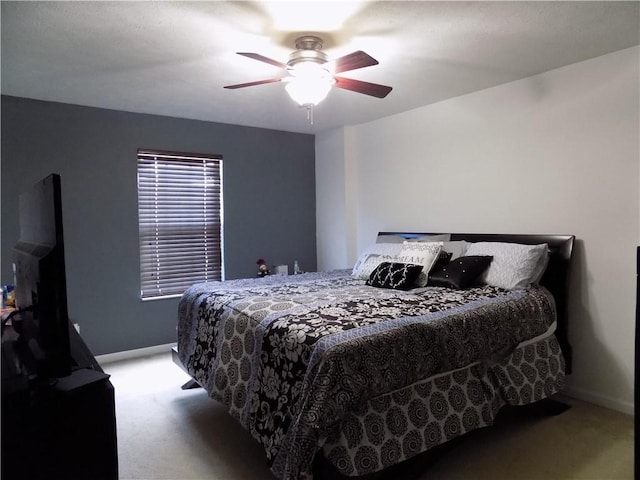 bedroom with a ceiling fan, light carpet, and baseboards