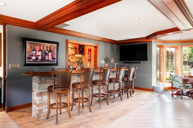 bar featuring visible vents, crown molding, indoor bar, and baseboards