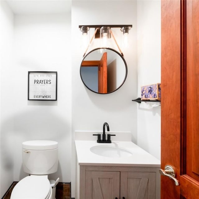half bath featuring toilet and vanity