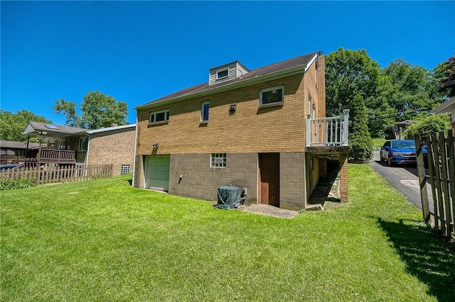 back of property featuring a lawn, a garage, and central AC