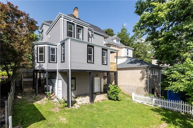 rear view of house with a lawn and cooling unit