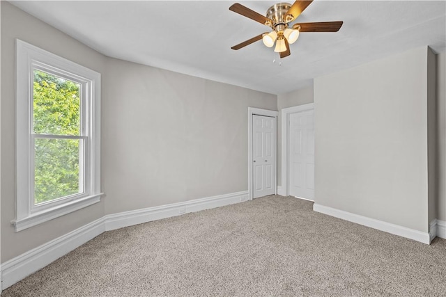 empty room featuring ceiling fan and carpet