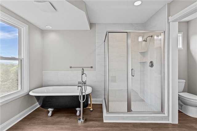 bathroom with hardwood / wood-style flooring, toilet, plenty of natural light, and independent shower and bath