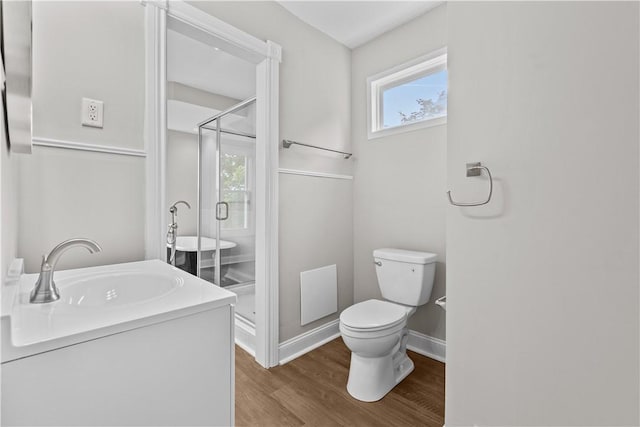 bathroom with hardwood / wood-style floors, vanity, toilet, and a shower with shower door