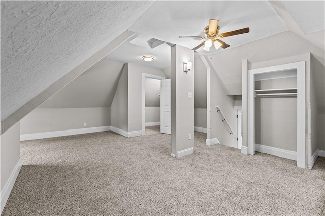 additional living space with a textured ceiling, ceiling fan, lofted ceiling, and light carpet