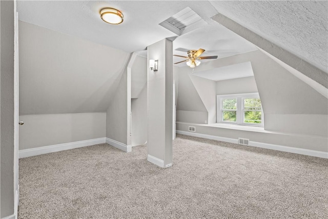 additional living space with carpet, ceiling fan, a textured ceiling, and vaulted ceiling