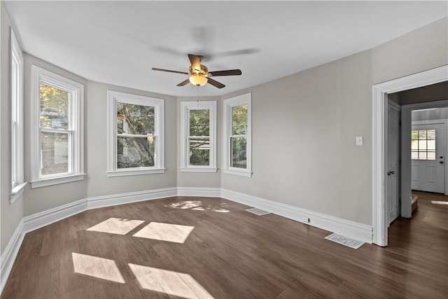 unfurnished room with ceiling fan and dark wood-type flooring