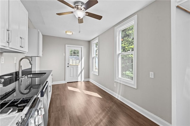 kitchen featuring white cabinets, stainless steel range oven, sink, and a wealth of natural light