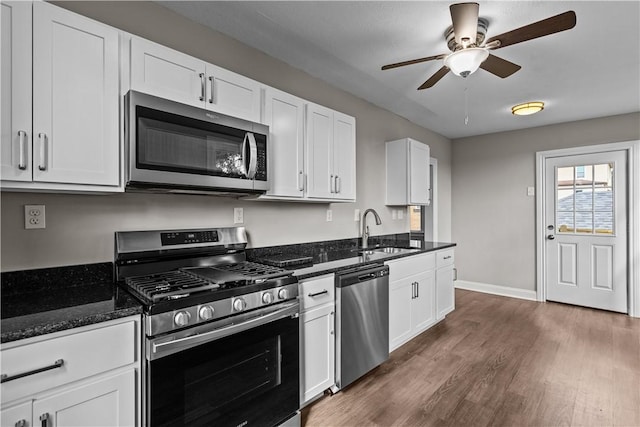 kitchen with dark hardwood / wood-style flooring, sink, white cabinets, and appliances with stainless steel finishes