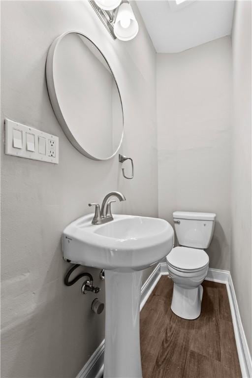 bathroom featuring toilet and wood-type flooring