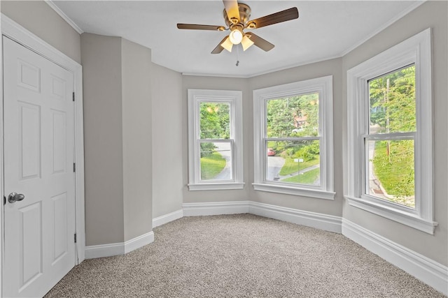 unfurnished room featuring carpet floors, a wealth of natural light, crown molding, and ceiling fan