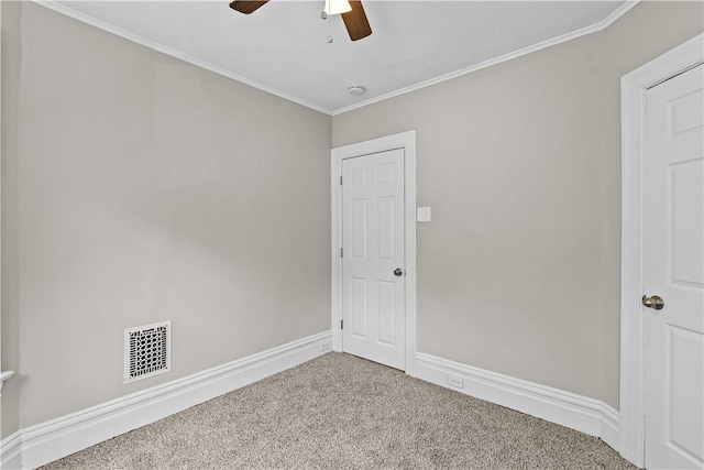 spare room featuring carpet, ceiling fan, and crown molding