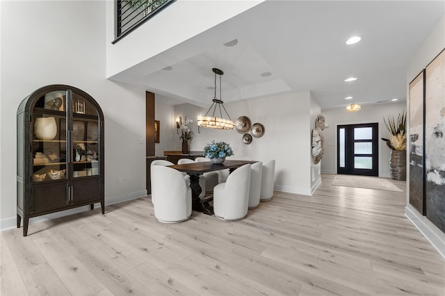 dining area with an inviting chandelier and light hardwood / wood-style floors