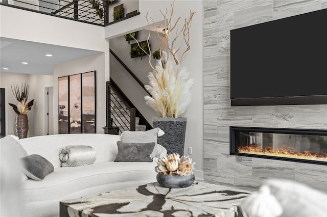 living room featuring tile walls, a high ceiling, and a fireplace