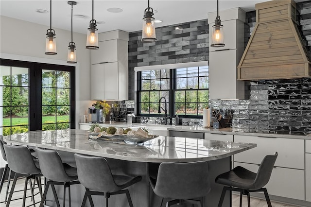 kitchen with backsplash, decorative light fixtures, and a healthy amount of sunlight