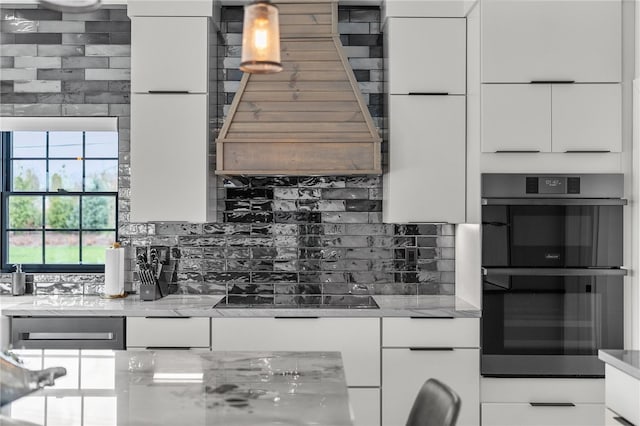 kitchen with backsplash, double wall oven, white cabinets, and black electric stovetop