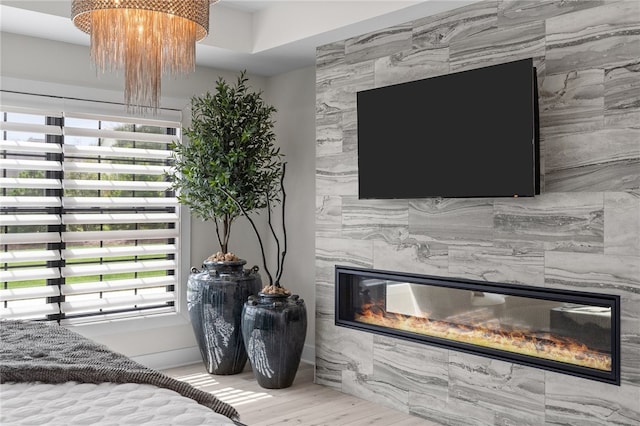 bedroom with hardwood / wood-style floors, a chandelier, a tile fireplace, and tile walls