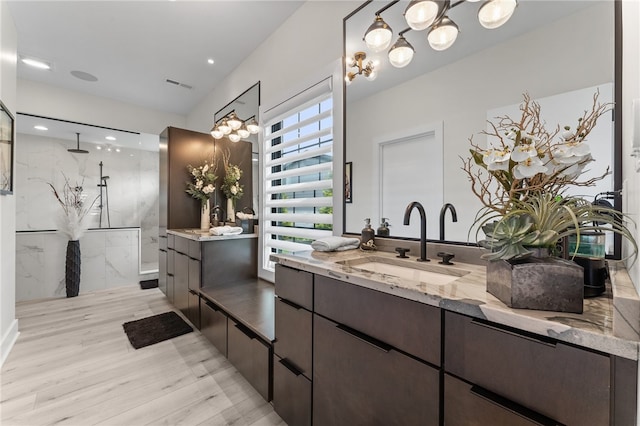 bathroom with vanity with extensive cabinet space, a chandelier, and wood-type flooring