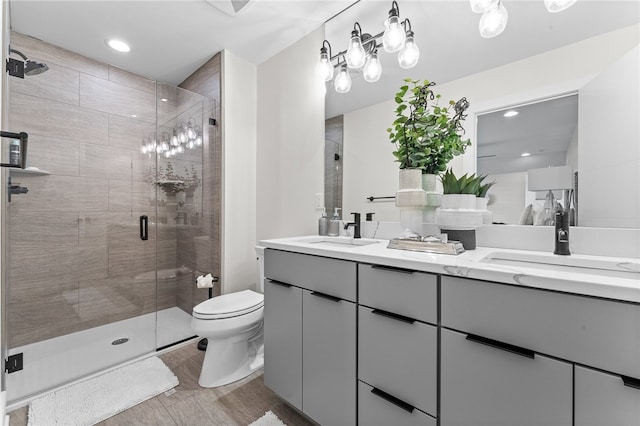 bathroom with walk in shower, dual bowl vanity, and toilet