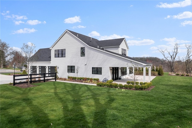 rear view of property with a yard and a patio area