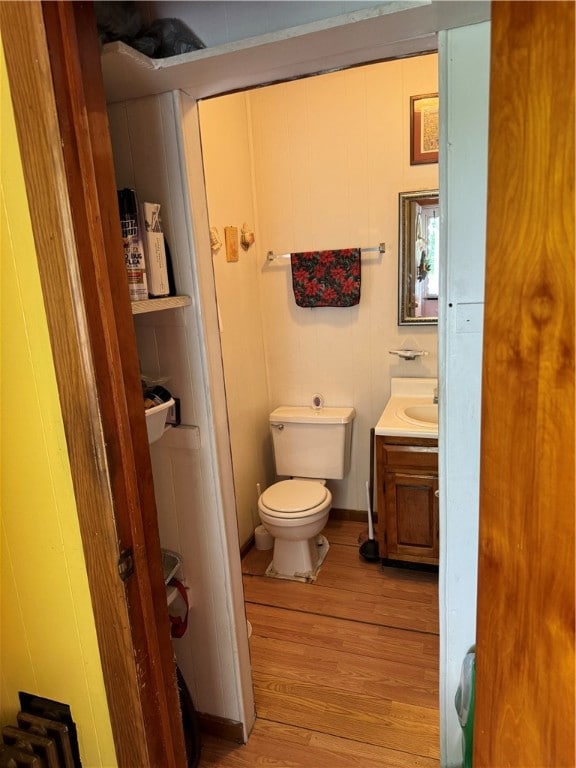 bathroom featuring wood-type flooring, toilet, and vanity