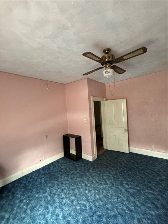 unfurnished bedroom featuring ceiling fan and dark colored carpet