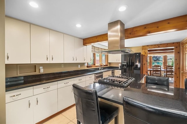 kitchen with white cabinetry, island range hood, light tile patterned floors, and appliances with stainless steel finishes