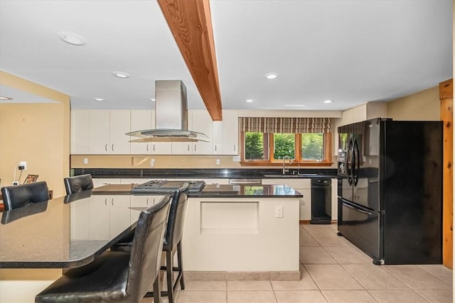 kitchen with black refrigerator, sink, wall chimney exhaust hood, light tile patterned floors, and beam ceiling