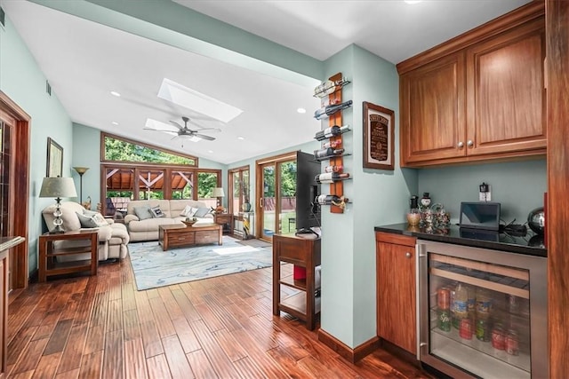 bar featuring vaulted ceiling, dark hardwood / wood-style floors, wine cooler, and ceiling fan